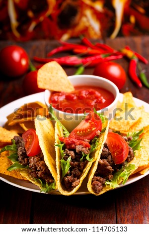 plate with taco, nachos chips and tomato dip