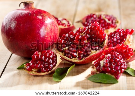 Pomegranate With Leafs On Wooden Table