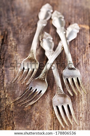 Vintage silverware forks lying on rustic wooden table