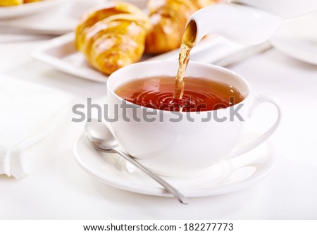 Pouring tea into cup of tea