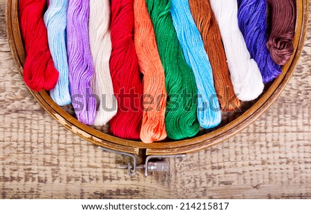 wooden hoop with threads for embroidery on wooden background