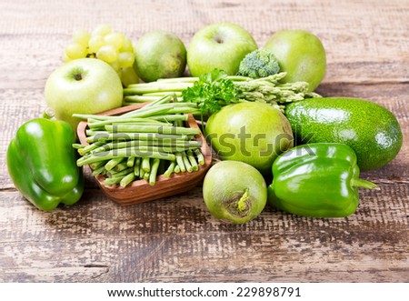 green fruit and vegetables on wooden background