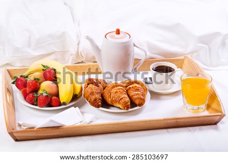 Breakfast in bed. Tray with coffee, croissants and fruits