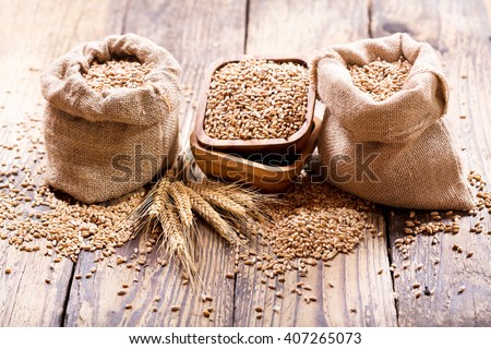 wheat grains in sacks on wooden table