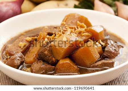 Traditional Indonesian food, Semur ayam (braised chicken with potatoes), with vegetables at the background