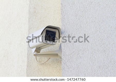 A new security camera is mounted on a wall.