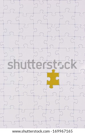 One piece in a white puzzle is colored.