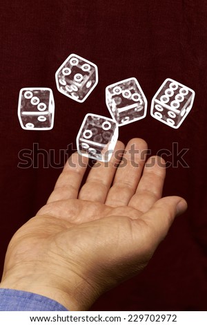 Five white dice hovering above a hand.
