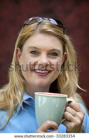 Beautiful young blonde woman holding coffee cup