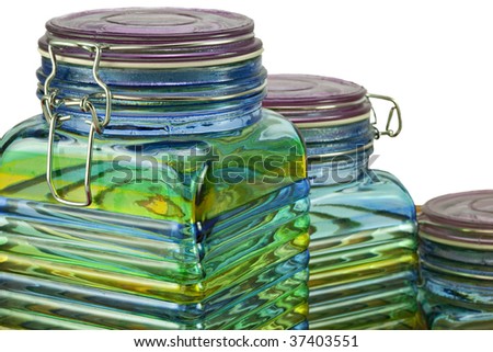 Three beautiful green, yellow and blue glass canisters or storage jars  isolated on white background