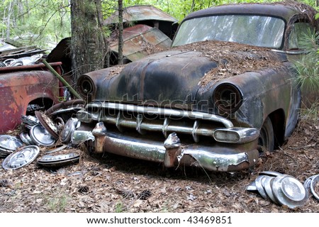 stock photo Old rusted car in junk yard