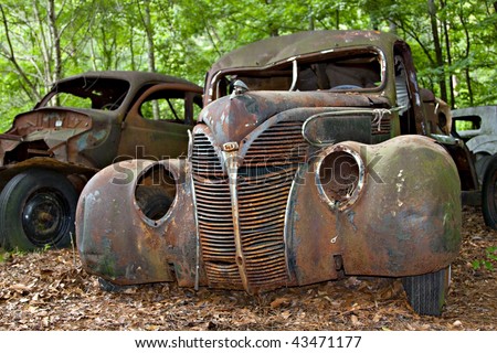 stock photo Old rusted car in junk yard