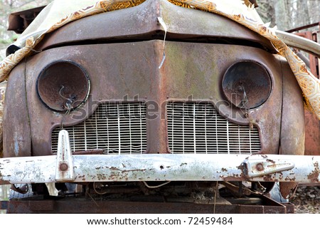 stock photo Junk yard vehicles showing old rusted car in overgrown weedy 