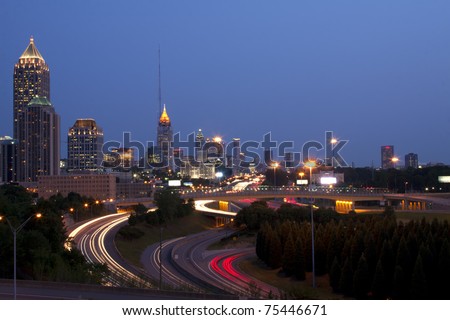 Sunrise or sunset downtown Atlanta skyline showing trails of car headlights and tail lights