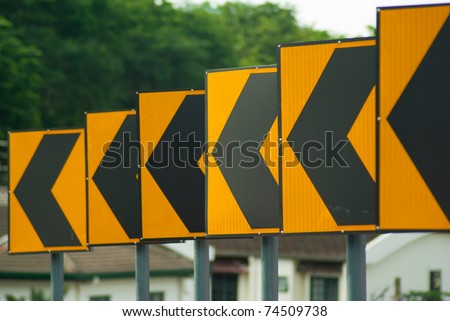 Black arrows on yellow traffic sign pointing left, Malaysia