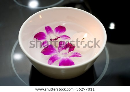 White Bowl with Water, Purple Orchids and Floating Tea light Candle on Black