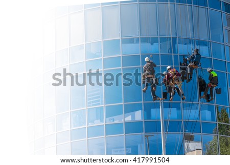 group of workers cleaning windows service on high rise building. work on the heights , industrial mountaineering. copyspase