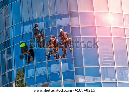 group of workers cleaning windows service on high rise building. work on the heights , industrial mountaineering