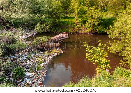 ecology concept. small river, water pollution, empty plastic bottles. River that is polluted with various garbage and trash, Polluted rivers,