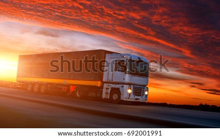 big White Truck on the Road in a Rural Landscape at Sunset. Picturesque Overcast Sky. over the Asphalt Road. Logistics Transportation and Cargo Freight Transport Industrial Business Commercial Concept