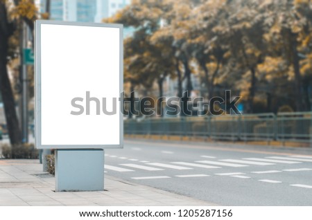 big blank billboard white LED screen vertical outstanding in the city on pathway side the road traffic for display advertisement text template promotion new brand at outdoor with green tree.