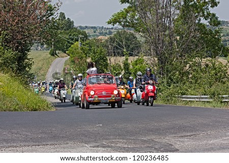 GOROLO DI BORGHI (FC) ITALY - JUNE 3: an old Fiat 500 leads the group of scooter riders in rally of Italian scooters \