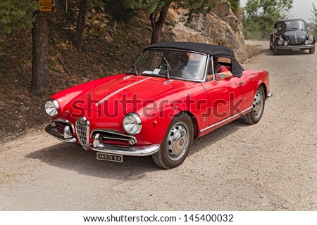 FOGNANO (RA), ITALY - JULY 7: unidentified crew on a vintage car Alfa Romeo Giulietta Spider runs on a dirt road during the rally \