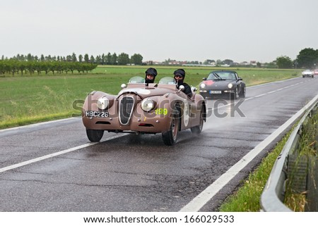 RAVENNA, ITALY - MAY 17: unidentified drivers on an old sports car Jaguar XK 120 OTS (1950) runs in rally Mille Miglia 2013, the italian historical race (1927-1957) on May 17, 2013 in Ravenna, Italy