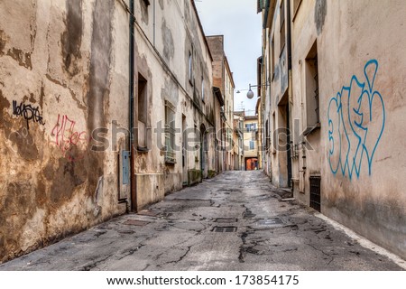 narrow dark alley in the old town - distressed alleyway in the italian city - urban decay, grunge aged street