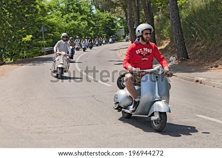 MONTIANO, FC, ITALY - MAY 25: a group of bikers riding a vintage italian scooters Vespa and Lambretta on the italian hills at the motorcycle rally \