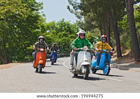 MONTIANO, FC, ITALY - MAY 25: a group of bikers riding a vintage italian scooters Vespa and Lambretta on the italian country at the motorcycle rally 