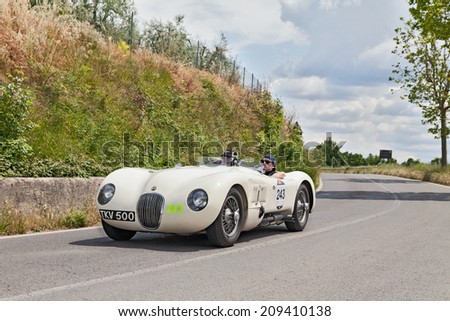 COLLE DI VAL D\'ELSA, SI, ITALY - MAY 17: Hans-Martin and Mahnaz Schneeberger on ancient racing car Jaguar C-Type (1952) in race Mille Miglia, on May 17, 2014 in Colle di Val d\'Elsa, Tuscany, Italy