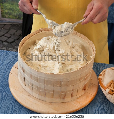 italian food: traditional artisan cheese making in a wooden mould - craft handmade production of italian cream cheese, typical of nord Italy
