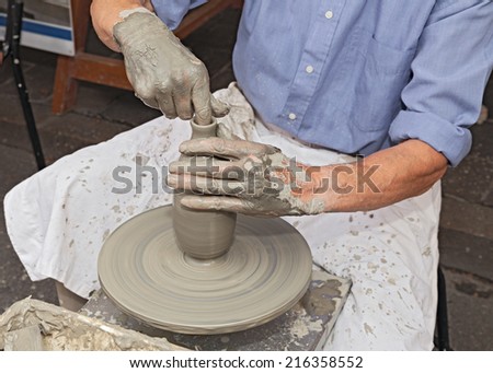 artisan ceramist creates a clay bottle with a lathe,- potter shaping clay on a potter\'s wheel