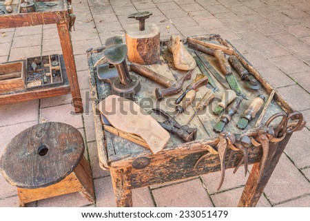 work table with old tools of the artisan shoemaker to cut and shape the leather to make shoes