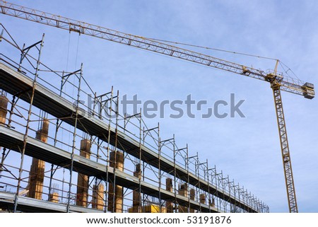 building yard - construction site with crane and scaffolding under a blue sky