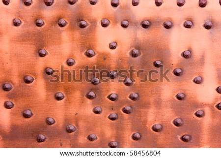 old copper panel with iron studs - metal texture - aged metallic plate