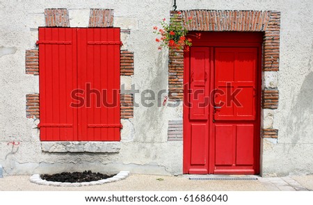 A wall with a red window and door