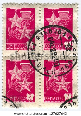 USSR - CIRCA 1976: A stamp printed in USSR shows image of the Gold Star Medal and The Hammer and Sickle medal, circa 1976.