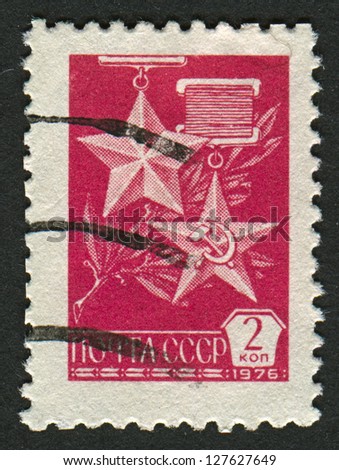 USSR - CIRCA 1976: A stamp printed in USSR shows image of the Gold Star Medal and The Hammer and Sickle medal, circa 1976.
