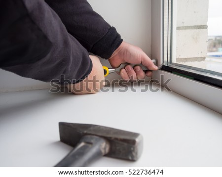 Worker removes the lock insulating glass of a plastic window