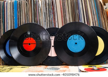 Retro styled image of a collection of old vinyl record lp\'s with sleeves on a wooden background.  Copy space.