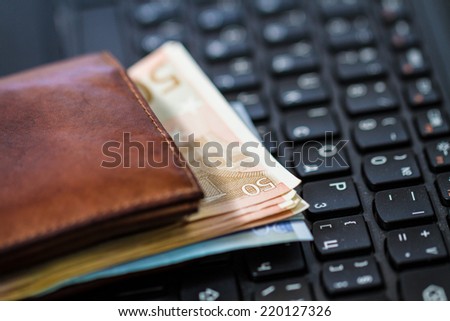 Wallet and  money on keyboard. Online banking.
