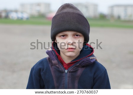 dramatic portrait of a little homeless boy