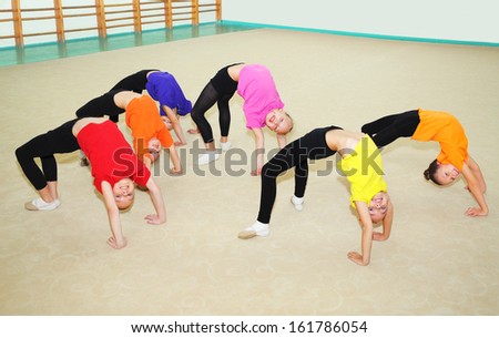 Happy children doing exercise in gym
