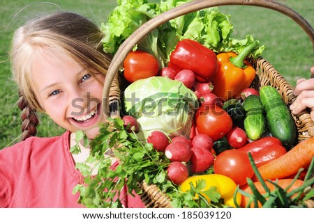 Smiling girl with basket of vegetables
