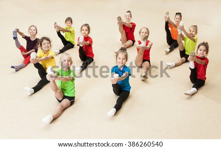 Little gymnasts doing exercises in gym