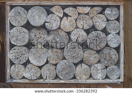Insect hotel with wooden border and wire mesh