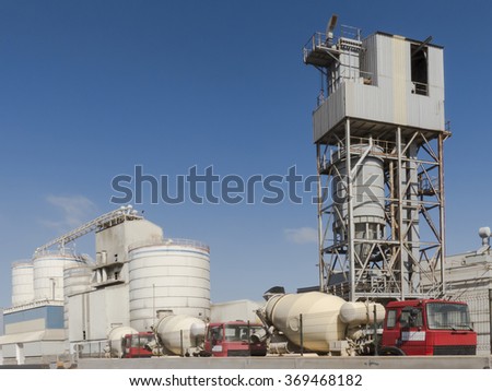 Cement factory with trucks in line waiting to load cement, construction material for delivery.
