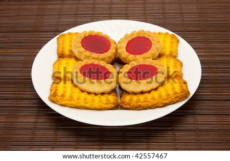 A plate of cookies on dark brown background